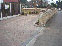 Thumbnail of the process of a block paved driveway with flower bed, brick wall surrounding property.